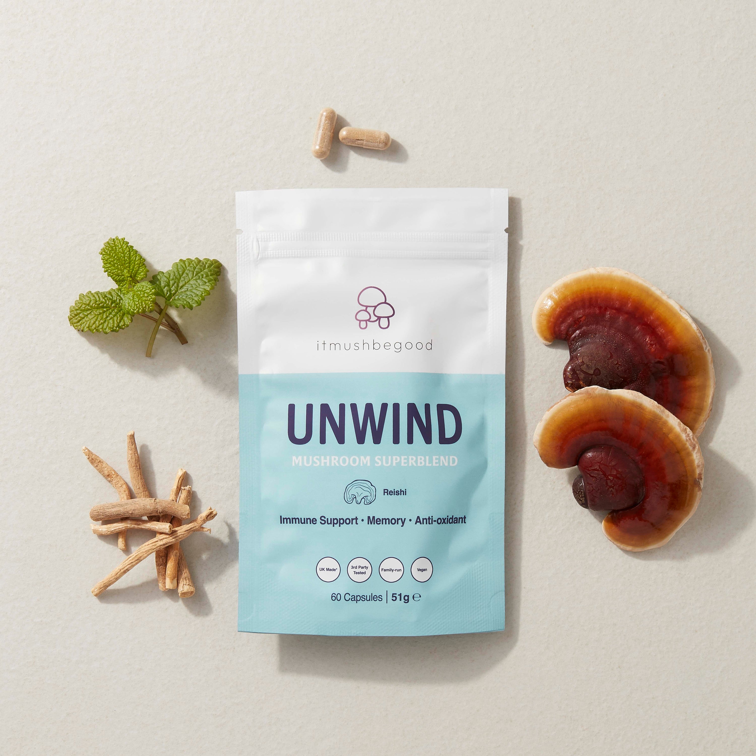 Unwind mushroom capsule packet surrounded by mushrooms and herbs